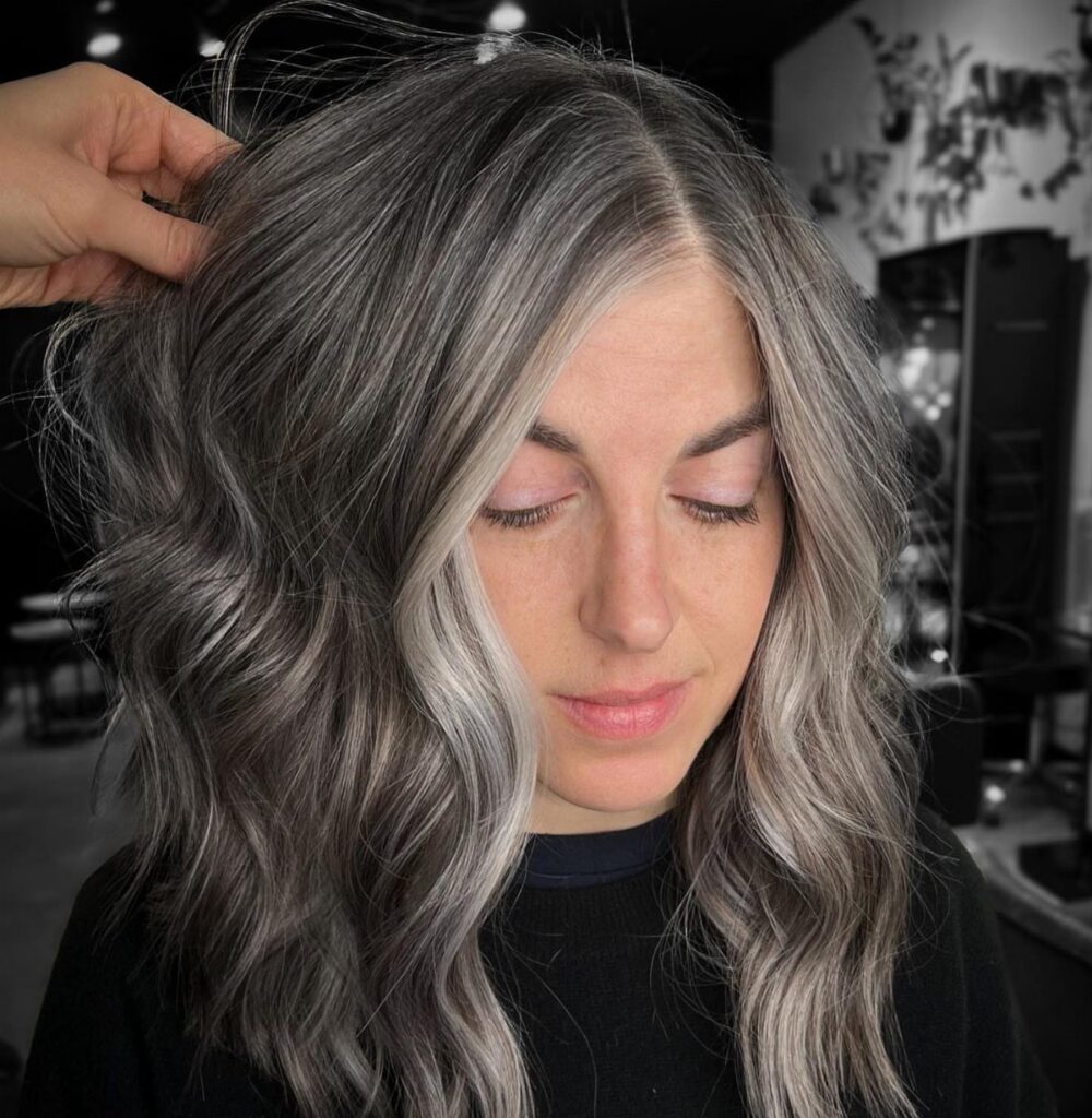 Wavy ash-gray hair with fine silver strands framing a woman's face