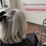 Gray-haired model beside sprays powders color products and silver hair swatches