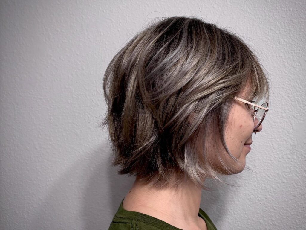 Layered brown and gray bob haircut with textured, feathered ends