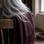 Woman seen from behind with dark ash and white hair in a salon chair