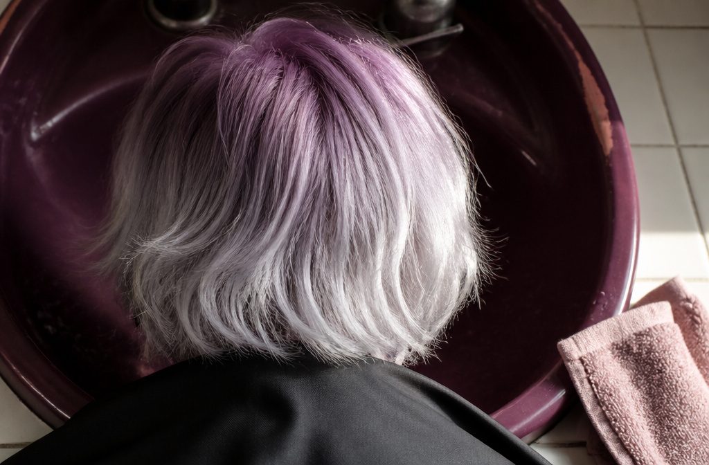 Purple roots fading through mid-lengths into silver hair ends